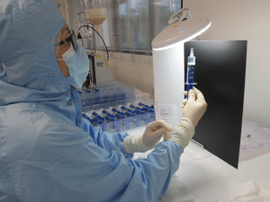 Women in smock and head cover looking at embolics