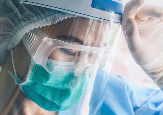 Covid-19 Response- Women in a medical mask, goggles, hair net, rubber gloves and clear face cover