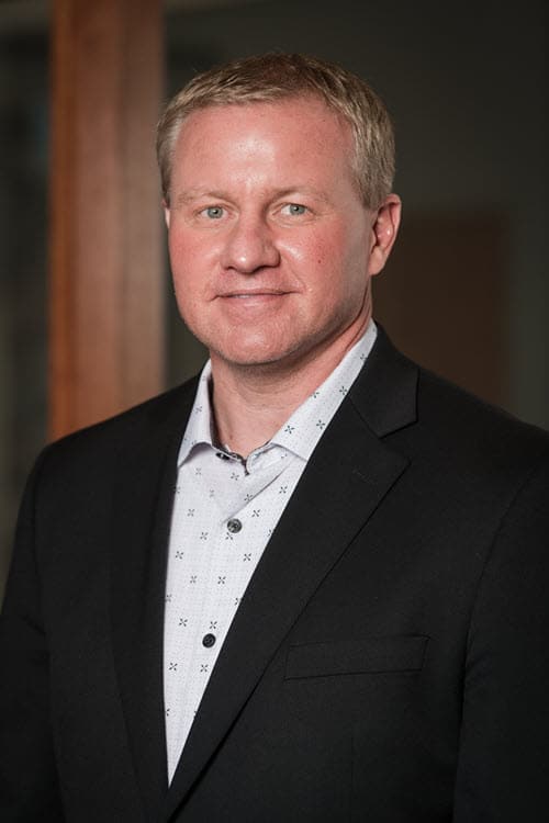 John Hall, VP of Advanced Materials Technology for Merit Medical, pictured in a dark suit and white button down shirt