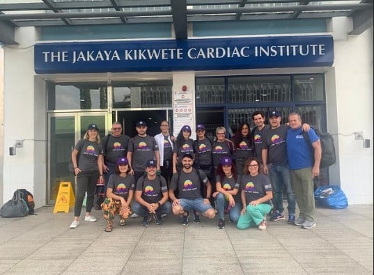 Healthcare professionals & volunteers standing in a group in front of the hospital
