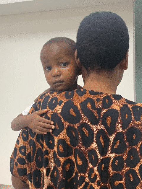 A young black child held by a adult woman